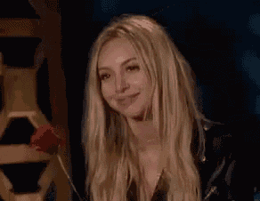 a woman with long blonde hair is laughing while holding a knife in her hand .