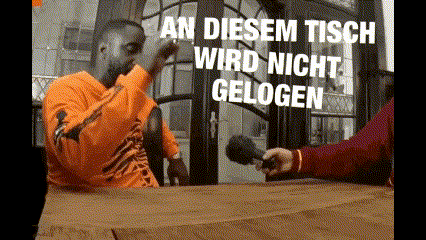 a man sitting at a table with the words an diesem tisch wird nicht gelogen written on the screen