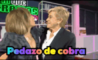 two women kissing in front of a sign that says que roots