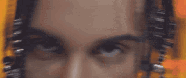 a close up of a person 's eyes with braids