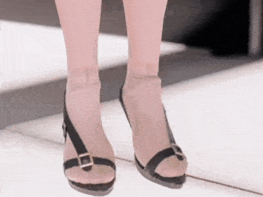 a woman wearing a pair of black sandals