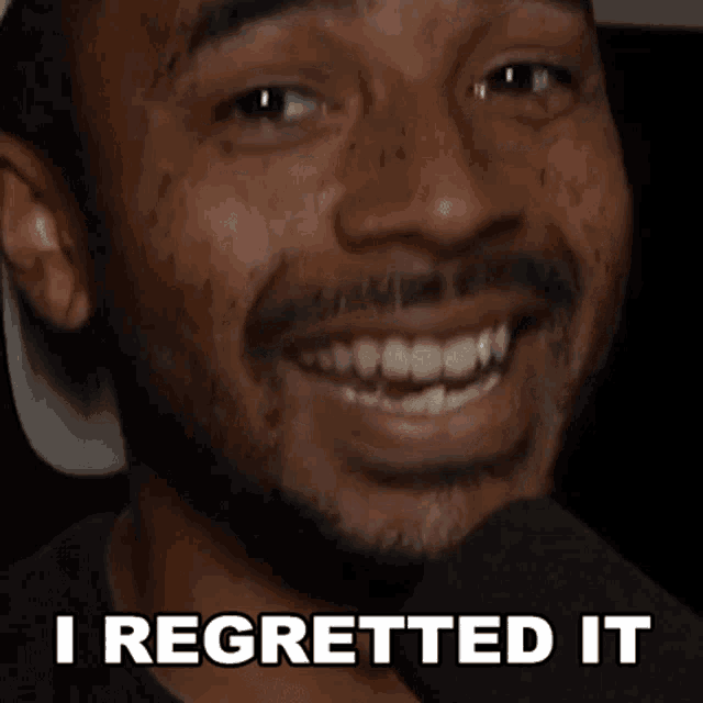 a man is smiling with the words " i regretted it " below him