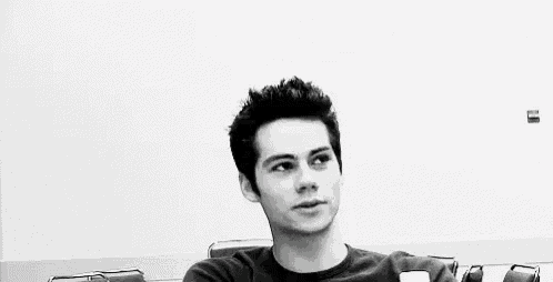 a young man is making a funny face with his mouth open in a black and white photo .