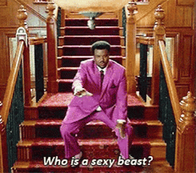 a man in a pink suit is dancing on a set of stairs with the caption " who is a sexy beast "