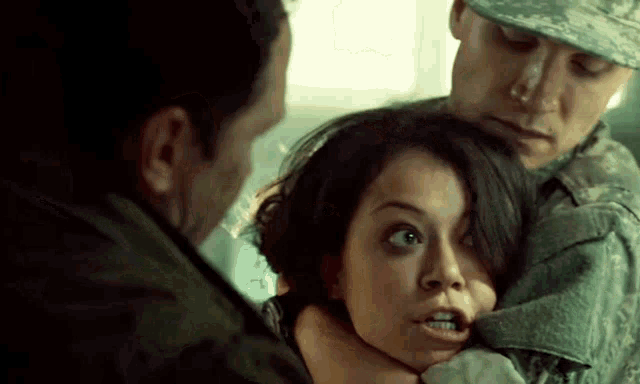 a woman is being held by a man in a military uniform .
