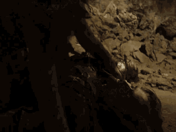 a woman is standing next to a man laying on the ground .