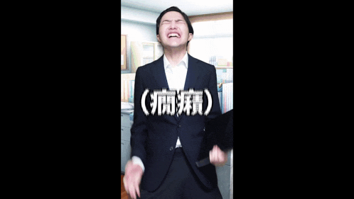 a man in a suit and tie is laughing in an office