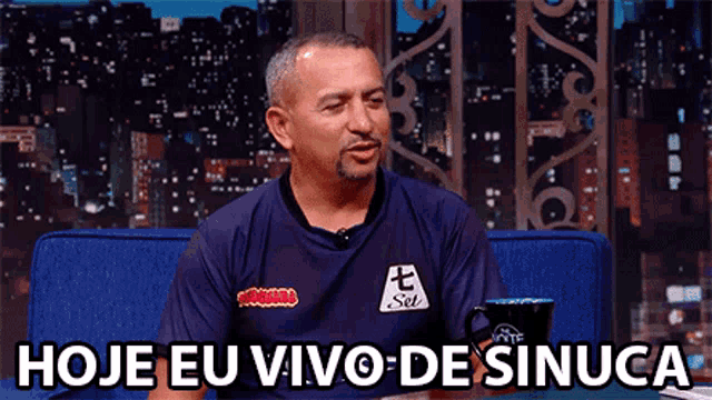 a man sitting on a couch with the words hoje eu vivo de sinuca below him