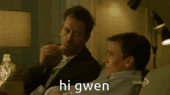 two men are sitting on a couch with the words hi gwen written on the screen