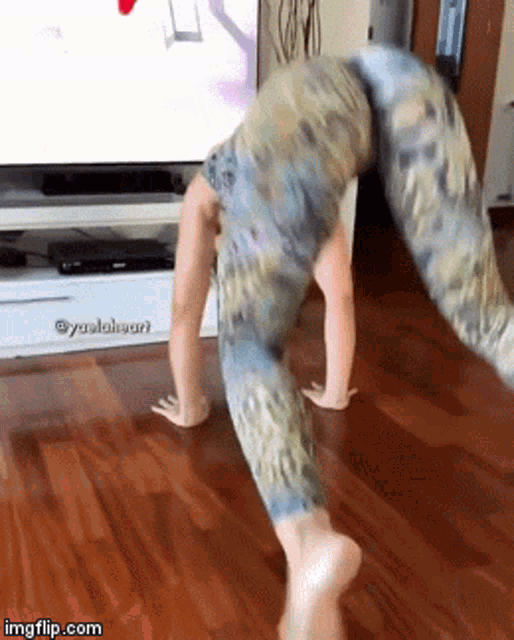 a woman is doing a handstand in front of a flat screen tv with imgflip.com at the bottom of the screen