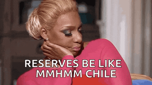 a woman in a pink shirt is sitting down with her hand on her chin and a caption that says `` reserves be like mmhmm chile ''