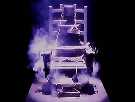 a electric chair with smoke coming out of it is sitting on a table .