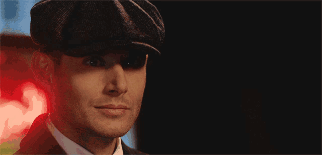 a close up of a man wearing a hat and suit
