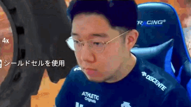 a man wearing glasses and an athletic originals shirt