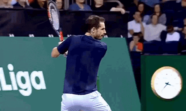 a tennis player is swinging a racket in front of a sign that says liga