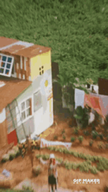 a person standing in front of a house with a sign that says gif maker on it