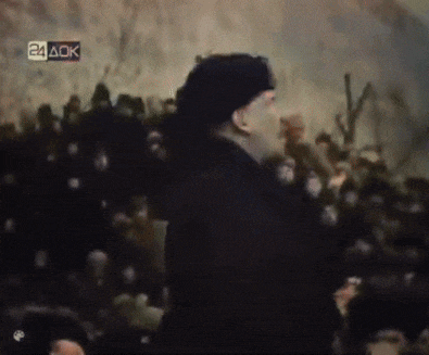 a man is standing in front of a crowd with a 24 aok sign above him