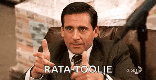 a man in a suit and tie is sitting in a chair and pointing .