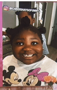 a girl wearing a mickey mouse shirt is smiling