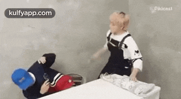 a man is laying on the floor while another man is standing over him .