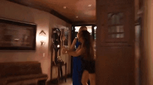 a woman in a blue dress is standing next to a woman in a black dress