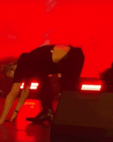 a man with red hair is doing push ups on the floor on a stage