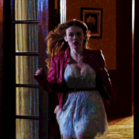 a woman in a white dress and red jacket is running in a hallway