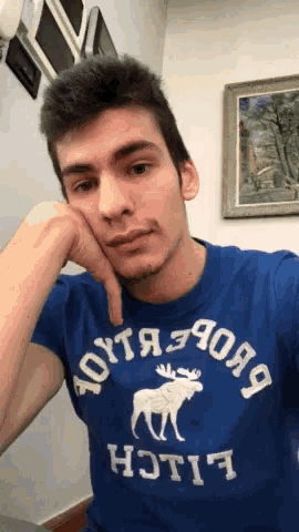 a young man wearing a blue shirt that says abercrombie