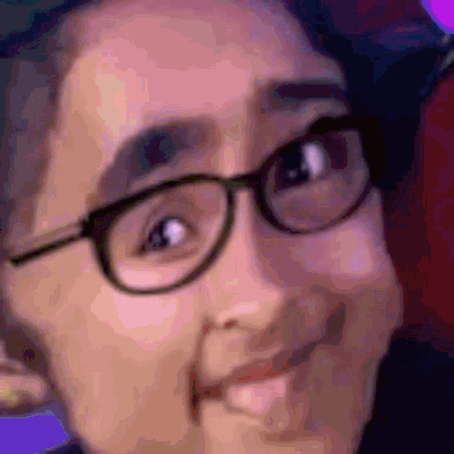 a close up of a person wearing glasses making a face