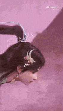 a close up of a woman 's head with a flower in her hair .