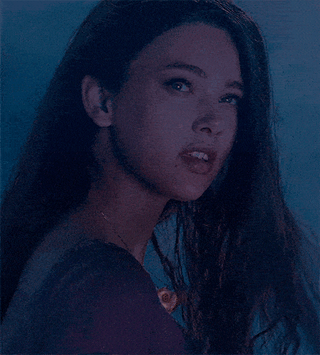 a close up of a woman 's face with long dark hair