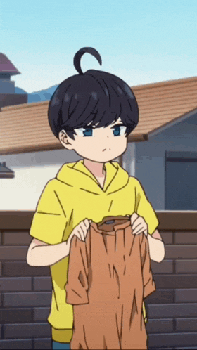 a boy in a yellow hoodie is holding a brown shirt with the letter w on it