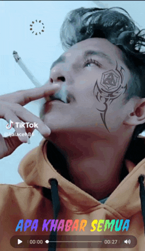 a man with a tattoo on his face is smoking a cigarette in a tik tok video