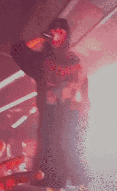 a blurry picture of a man singing into a microphone in a dark room