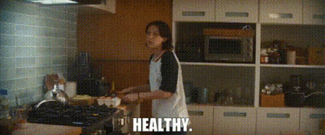 a woman is cooking in a kitchen and the word healthy is on the bottom