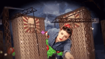 a woman is flying through the air in front of a building with a man 's face painted on it