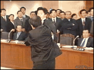 a man in a suit is standing in front of a group of people with the website 4gifs.com visible in the corner