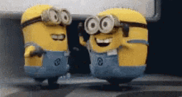 two minions are standing next to each other in a room .