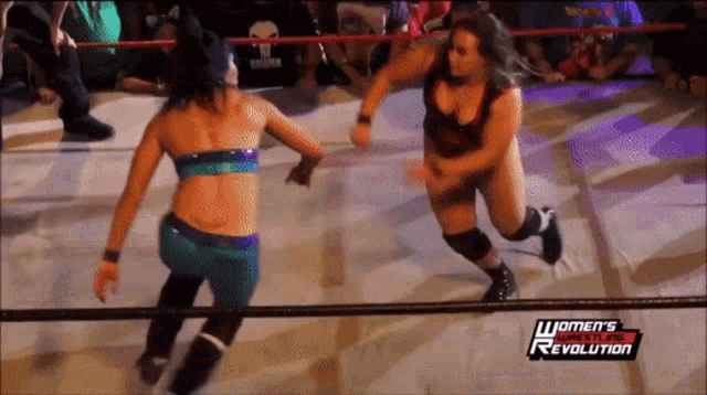 two women wrestling in a ring with the words women 's wrestling revolution on the bottom