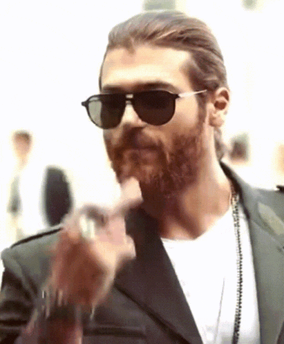 a man with a beard wearing sunglasses and a necklace