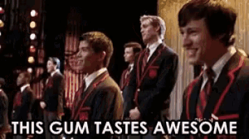 a group of men standing on a stage with the words this gum tastes awesome
