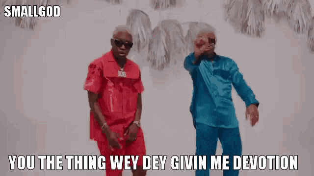 a man in a red shirt is standing next to another man in a blue shirt and they are dancing together .