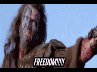a man with a scar on his face is holding a gun and says freedom
