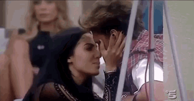a man and a woman are kissing each other in a room .