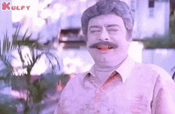 a man with a mustache is making a funny face while standing in front of a palm tree .