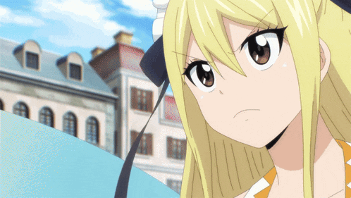 a girl with blonde hair and brown eyes is standing in front of buildings