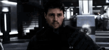 a man with a beard wearing a black jacket with the letter a on it