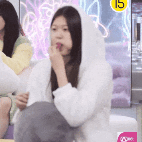 a girl wearing a white hoodie with the number 15 on the bottom
