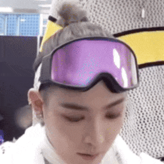 a close up of a person wearing a bun and goggles .