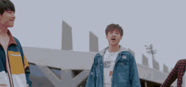 a young man wearing a denim jacket and a t-shirt that says tommy jeans